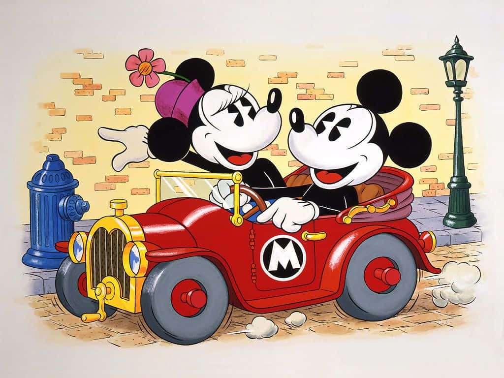 Mickey And Minnie Mouse 桌布 壁紙 — 米奇和米妮老鼠快樂地駕駛一輛紅色復古車沿著鵝卵石街道行駛，經過藍色消防栓和磚牆。