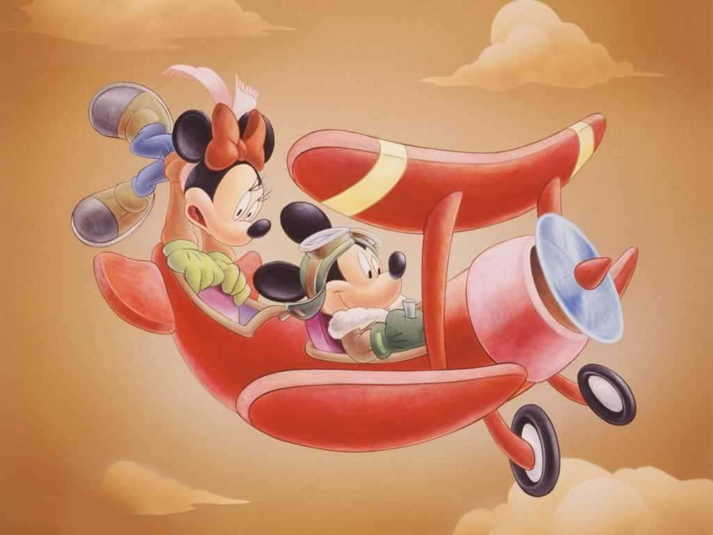 Mickey And Minnie Mouse 桌布 壁紙 — 米奇和米妮老鼠快樂地駕駛紅色雙翼飛機穿過溫暖的金色雲層，這是一幅經典的迪士尼插圖。