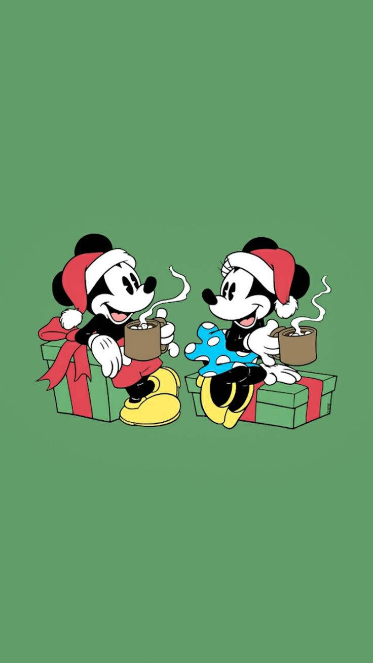 米奇和米妮戴聖誕帽在綠色背景前從禮物上喝可可