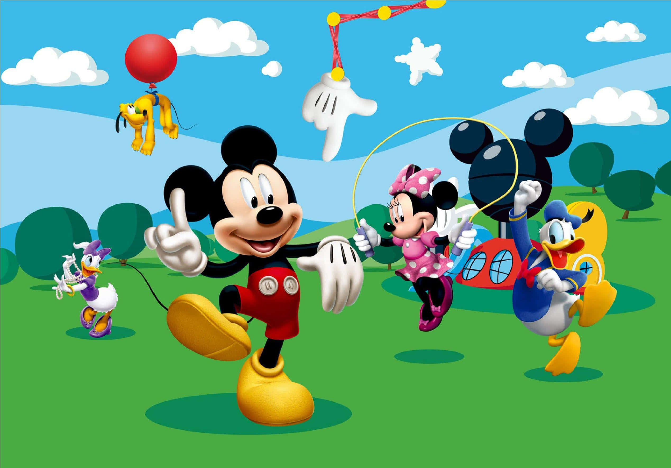 Mickey Mouse Home 桌布 壁紙 — 米奇老鼠和朋友們在藍天白雲下的一片明亮綠色田野中快樂地玩耍。