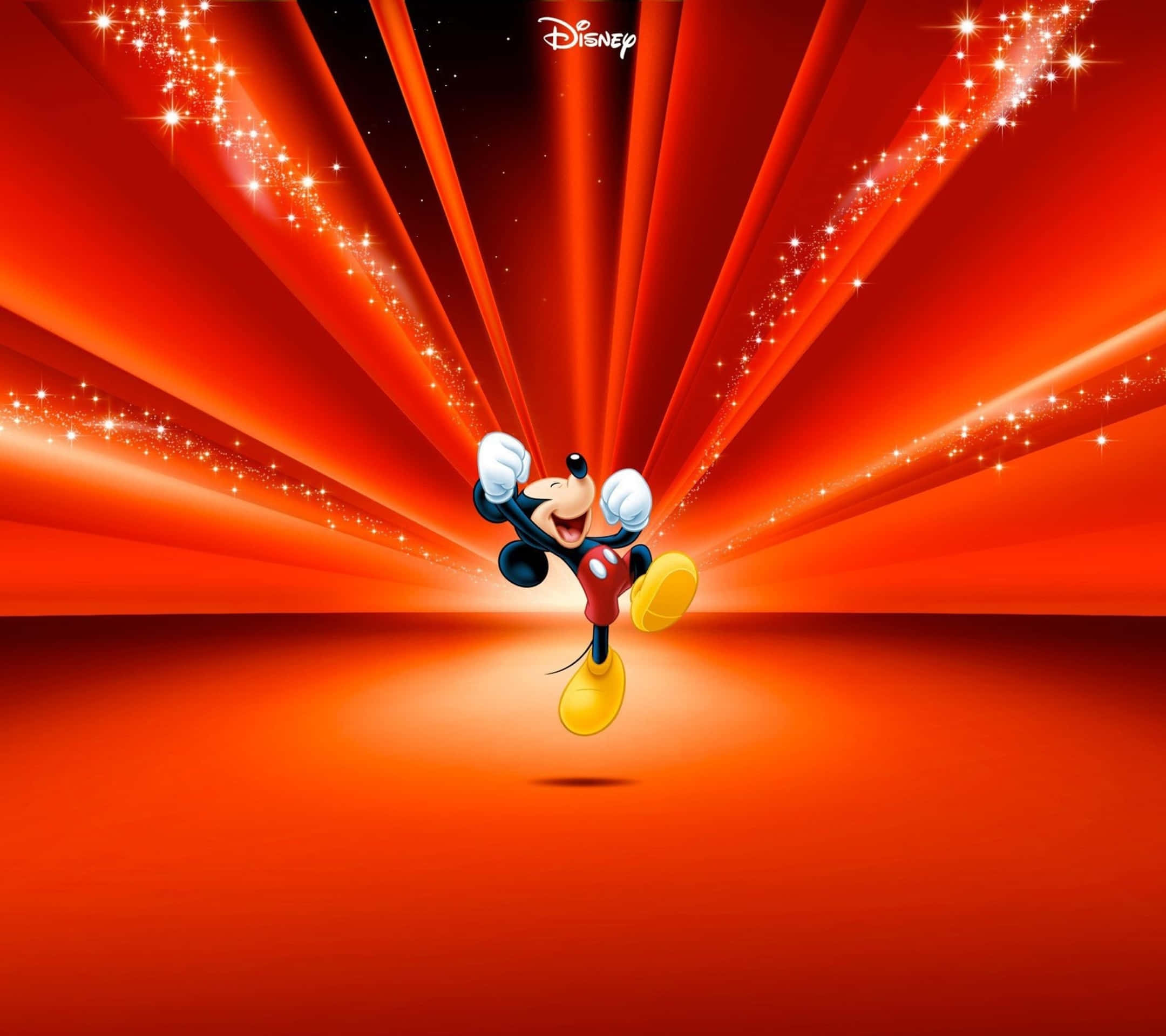 Entertainment 桌布 壁紙 — 米奇老鼠在閃爍的紅色背景上，伴隨閃耀的光線，開心地跳躍。