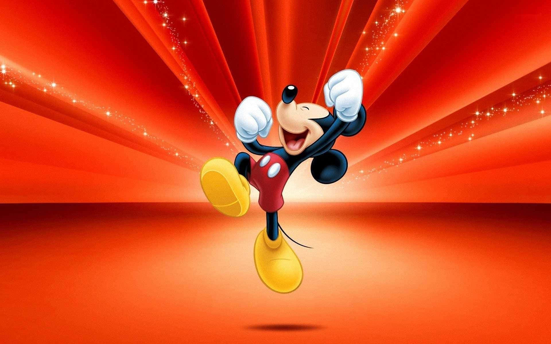 Mickey Mouse Desktop 桌布 壁紙 — 米奇老鼠在閃爍的紅色背景上，伴隨著閃耀的光線，開心跳躍。