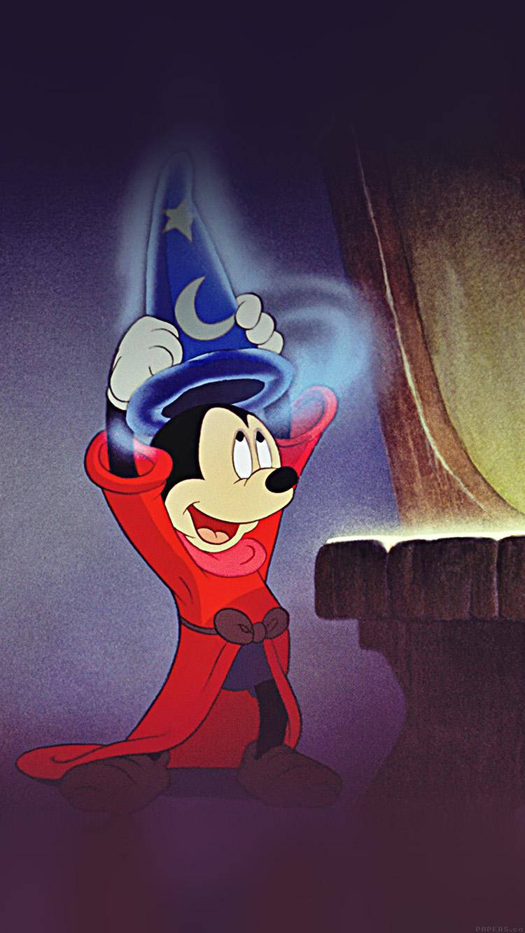 Mickey 桌布 壁紙 — 米奇老鼠身穿紅色長袍和藍色巫師帽，在黑暗的洞穴中，魔法藍色能量在他雙手周圍旋轉，他滿面笑容。
