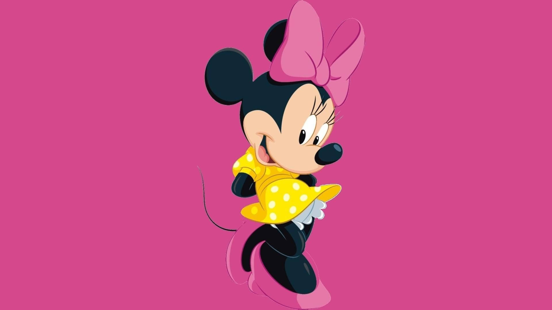 minnie 桌布 壁紙 — 米妮老鼠穿著黃色圓點裙和粉紅色蝴蝶結，在純粉紅色背景上開心地微笑。