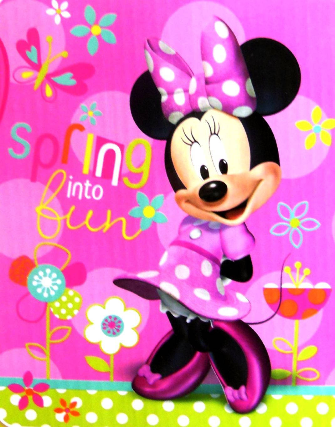 minnie 桌布 壁紙 — 米妮老鼠身穿粉紅色圓點連衣裙和蝴蝶結，在充滿活力的粉紅色背景上，伴隨著色彩繽紛的花朵和文字 spring into fun，開心地微笑。