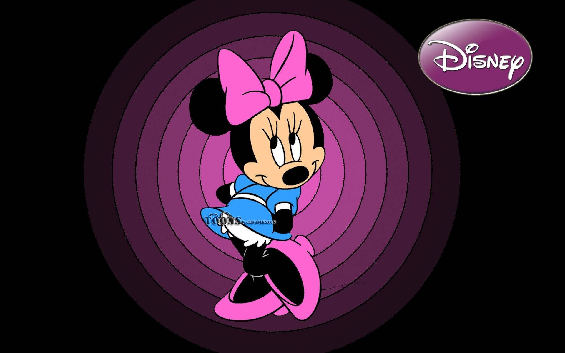 minnie 桌布 壁紙 — 米妮老鼠身穿藍色連衣裙和粉紅色蝴蝶結，自信地站在旋轉的紫色同心圓背景前。