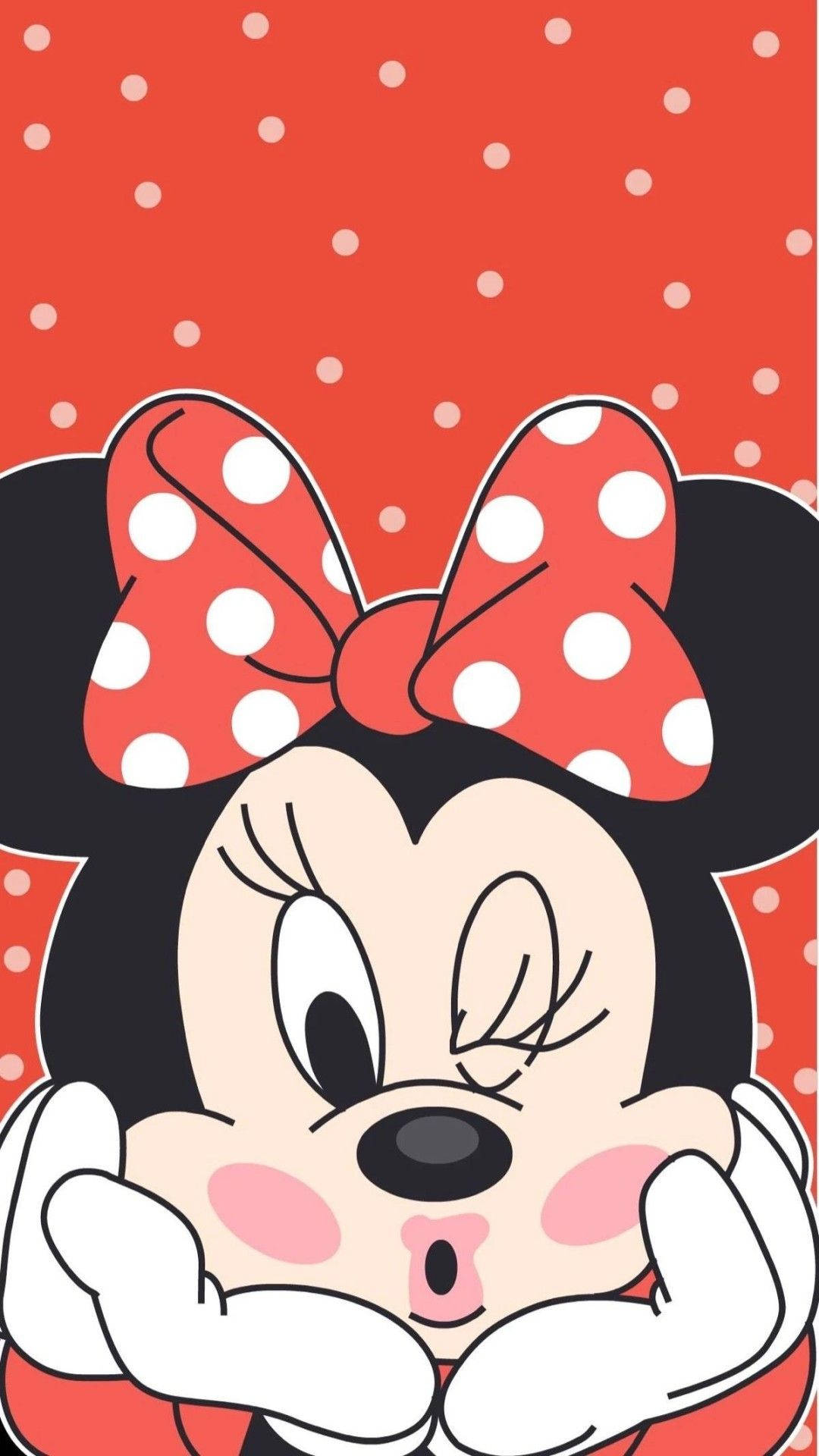 minnie 桌布 壁紙 — 米妮老鼠雙手捧著臉頰，在紅色圓點背景上俏皮地眨眼。
