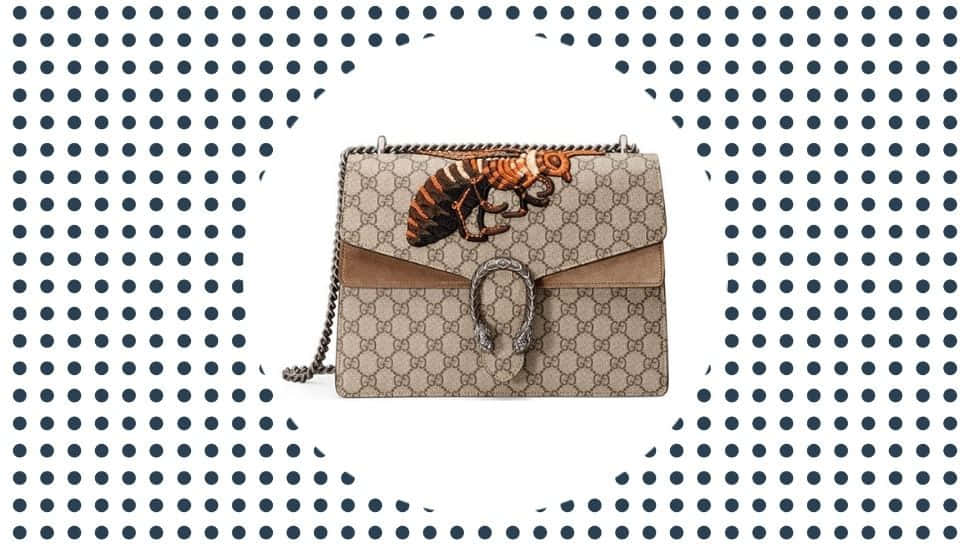 Gucci 桌布 壁紙 — 米色Gucci手提包，帶有老虎貼花和銀色五金件，置於海軍藍波點背景上。