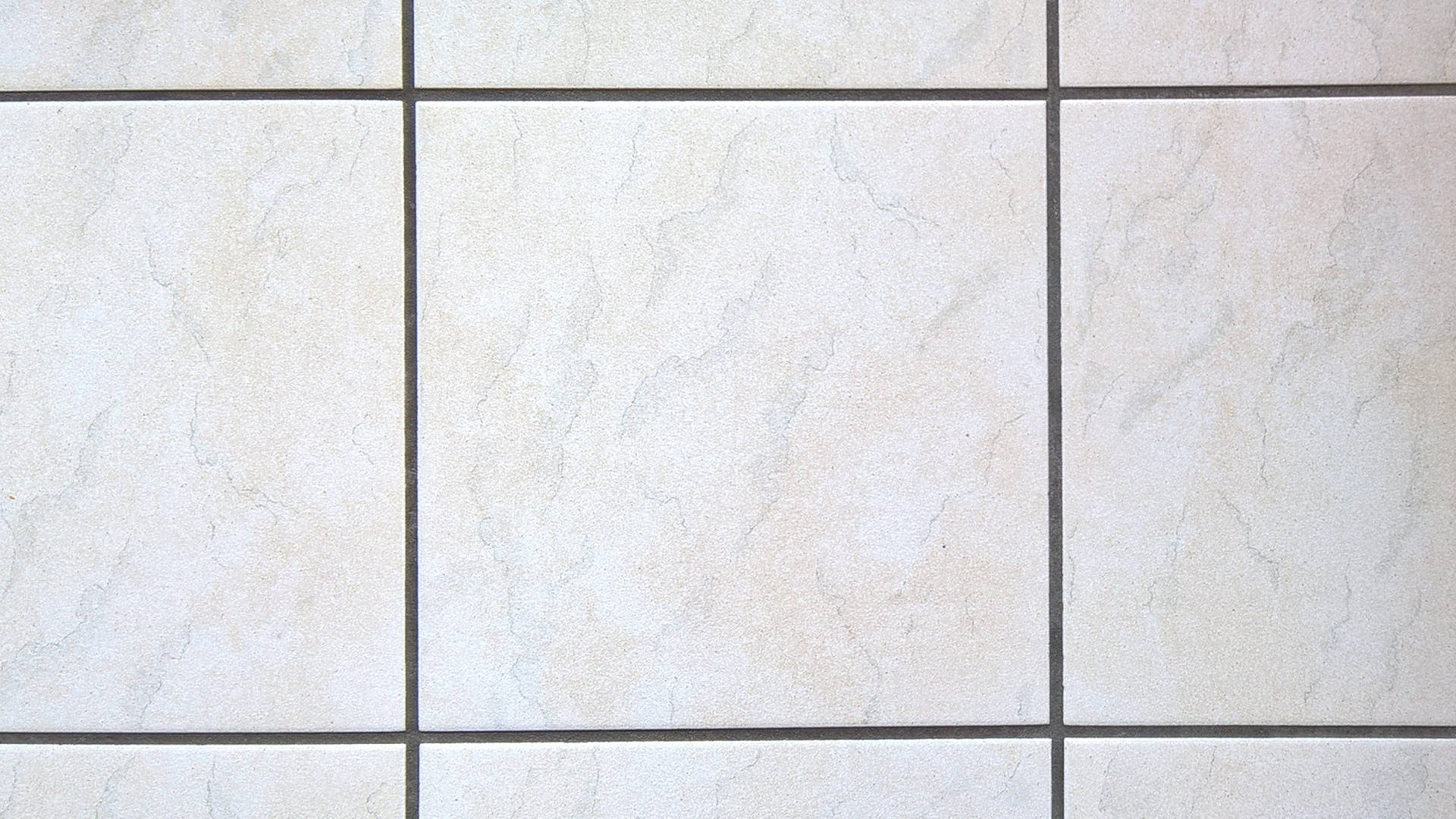 Floor Tiles 桌布 壁紙 — 米色大理石紋瓷磚特寫，深色填縫線排列成網格圖案。