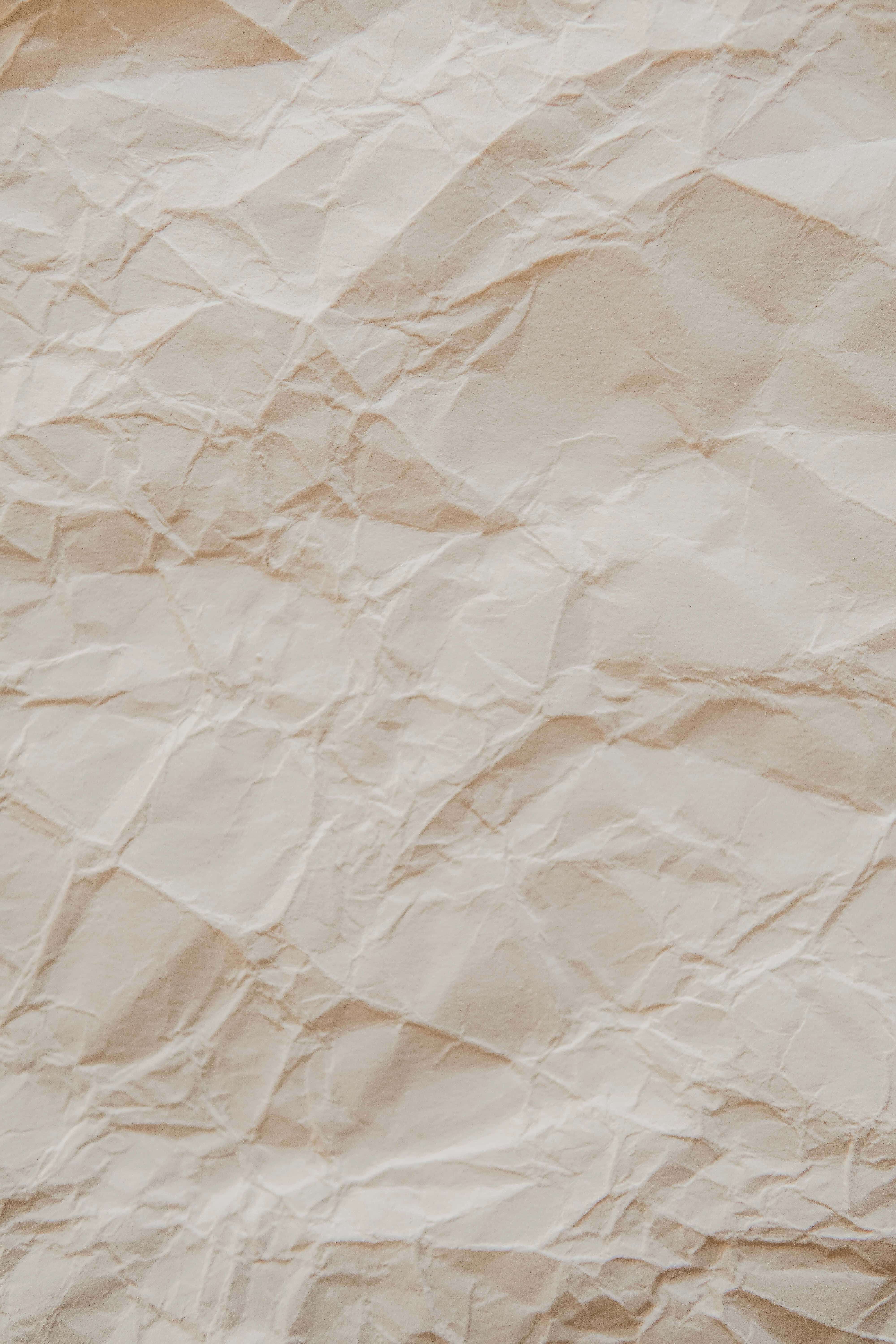 Old Paper 桌布 壁紙 — 米色皺紋紙的微距特寫，具有紋理、柔和陰影和自然摺痕。