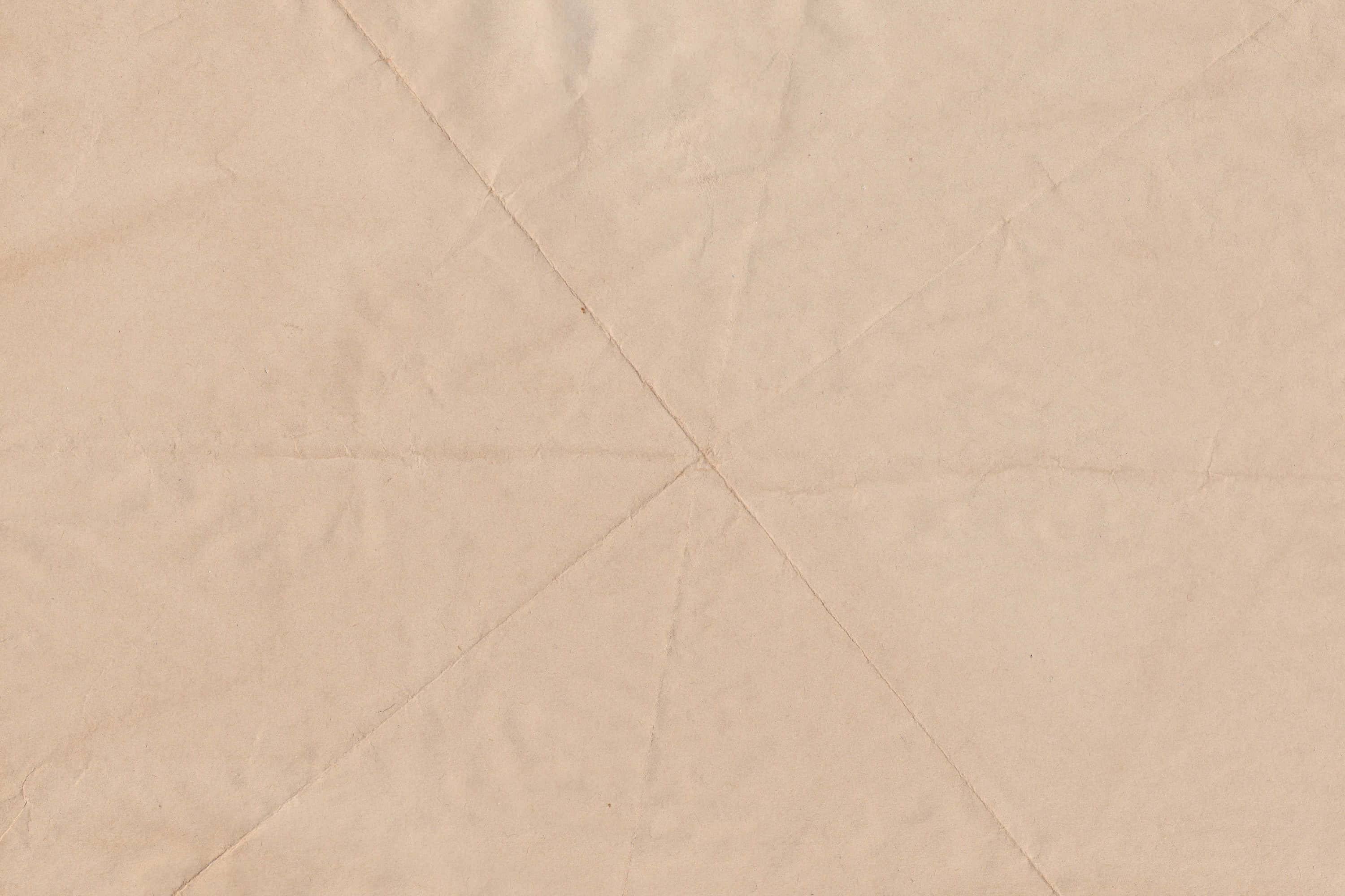 Brown Paper 桌布 壁紙 — 米色皺紙的特寫，可見從中心點形成放射狀圖案的摺痕。