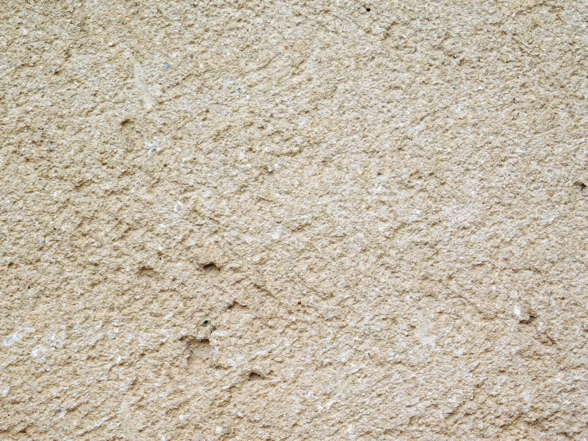 Stone texture 壁紙 — 米色粗糙灰泥牆的特寫，帶有細微的白色斑點和不均勻的紋理。