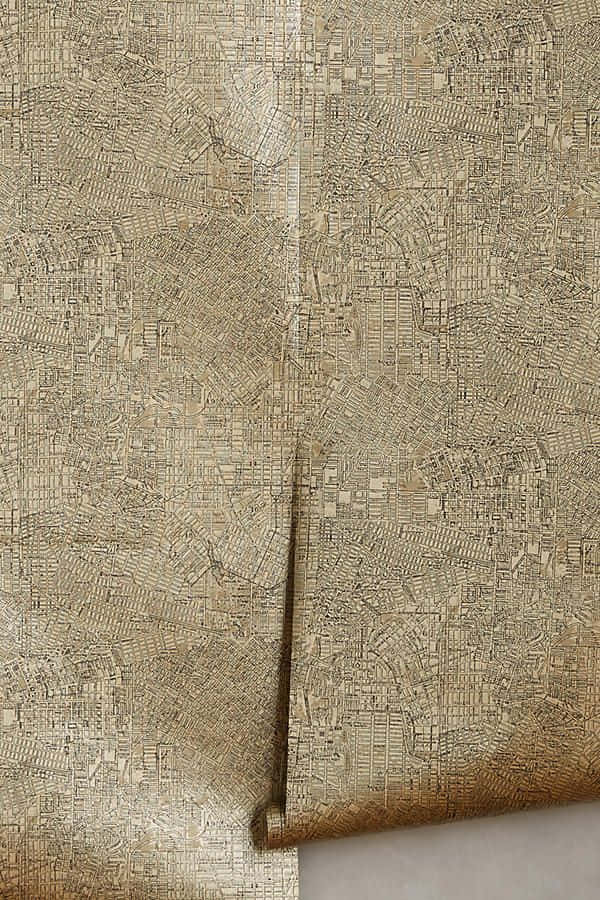 金屬質感 桌布 壁紙 — 米色紋理壁紙的特寫，帶有複雜的壓花城市地圖圖案和捲邊。