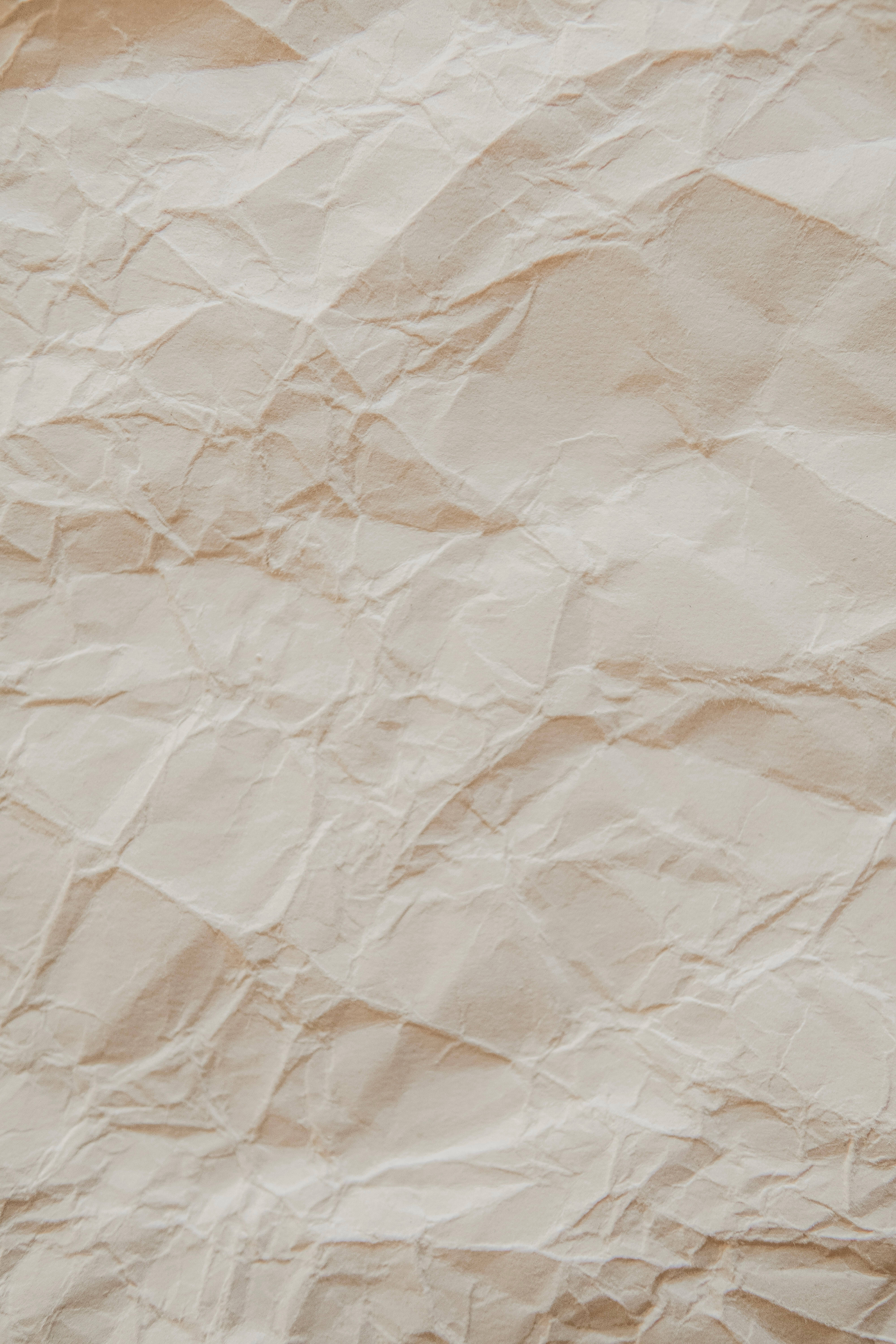 paper 桌布 壁紙 — 米色紋理皺紙的特寫，帶有柔和陰影和自然摺痕。