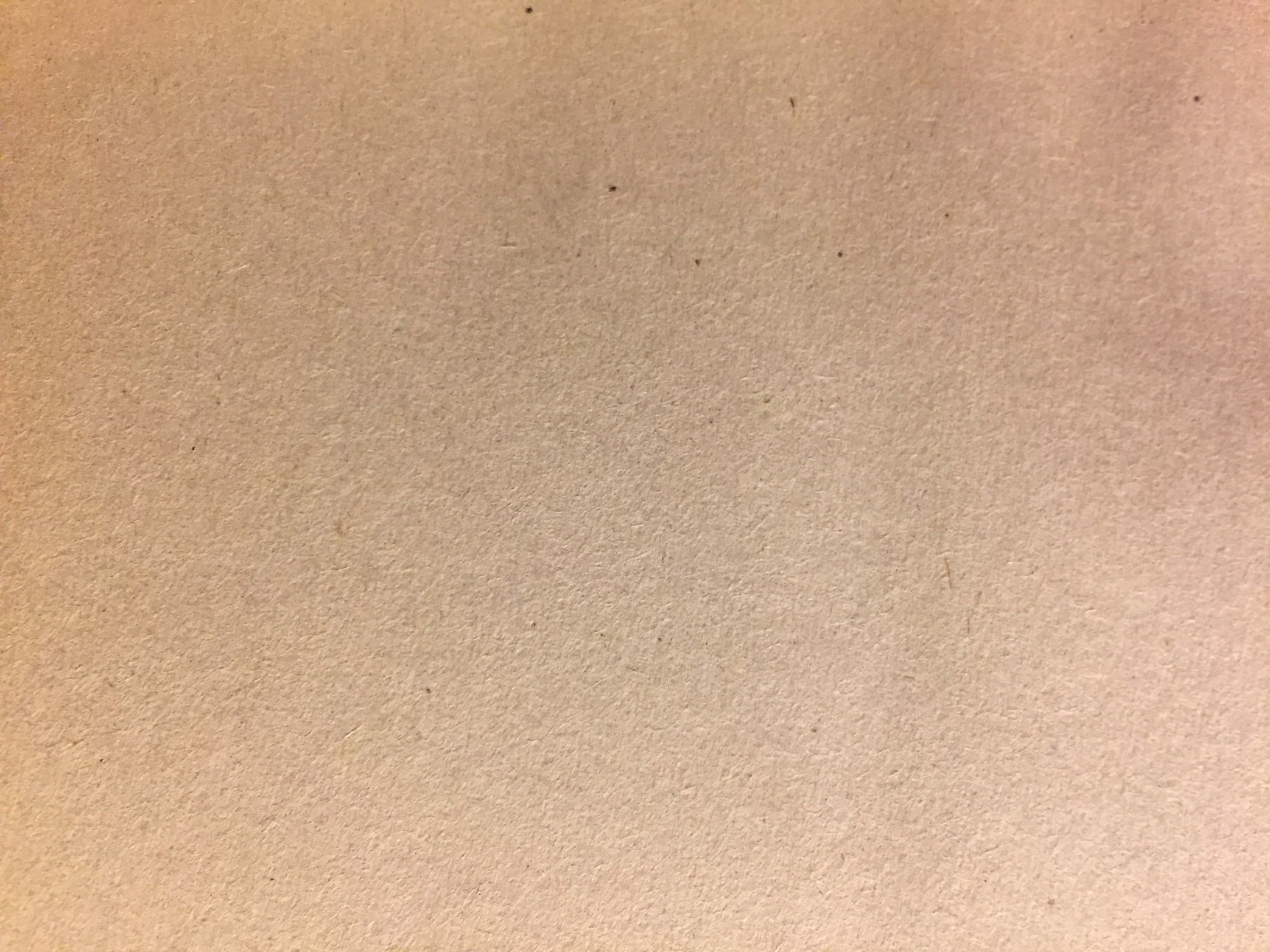 Paper Texture 桌布 壁紙 — 米色紋理紙張的特寫，表面帶有微妙的色調變化和淡淡的斑點。