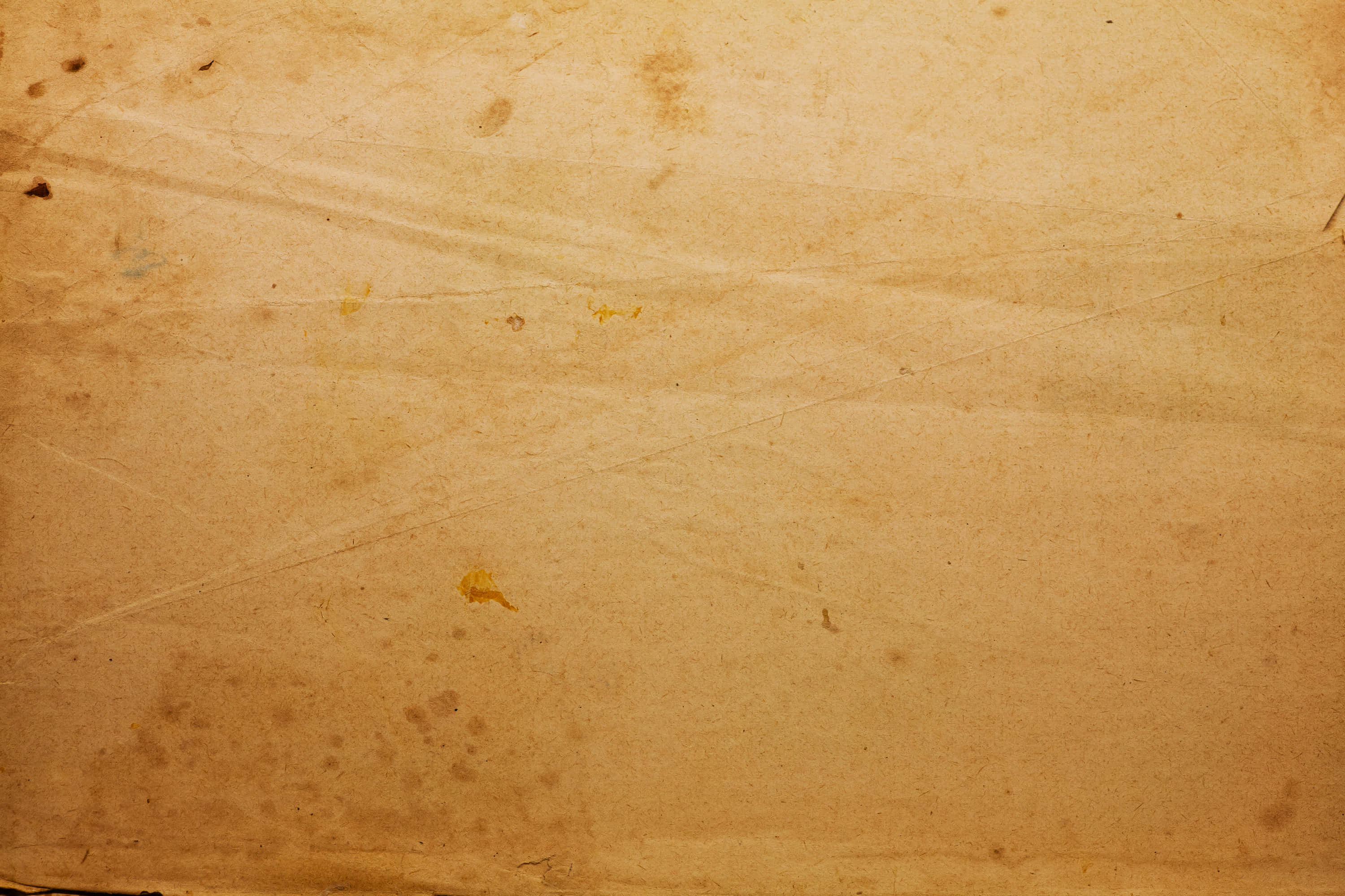 Old Paper 桌布 壁紙 — 米色舊紙的特寫，帶有摺痕、污漬和細微紋理，顯示隨著時間的磨損。