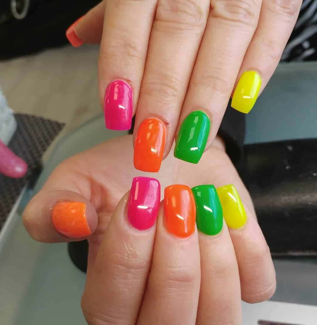 Spring Nails 桌布 壁紙 — 粉紅、橙、綠、黃色的鮮豔螢光指甲以彩虹圖案排列在手上。