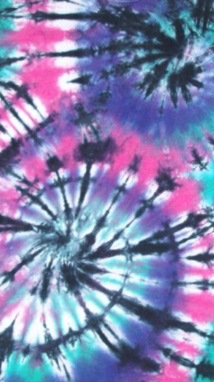 Purple Tie Dye 桌布 壁紙 — 粉紅、紫色和藍綠色的鮮豔紮染漩渦從中心點向黑暗背景輻射。