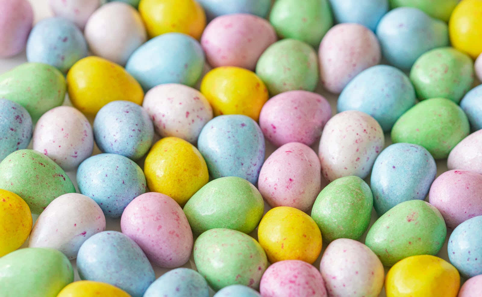 Pastel Easter 桌布 壁紙 — 粉紅、黃、綠、藍色柔和色調的彩色斑點糖果蛋特寫。