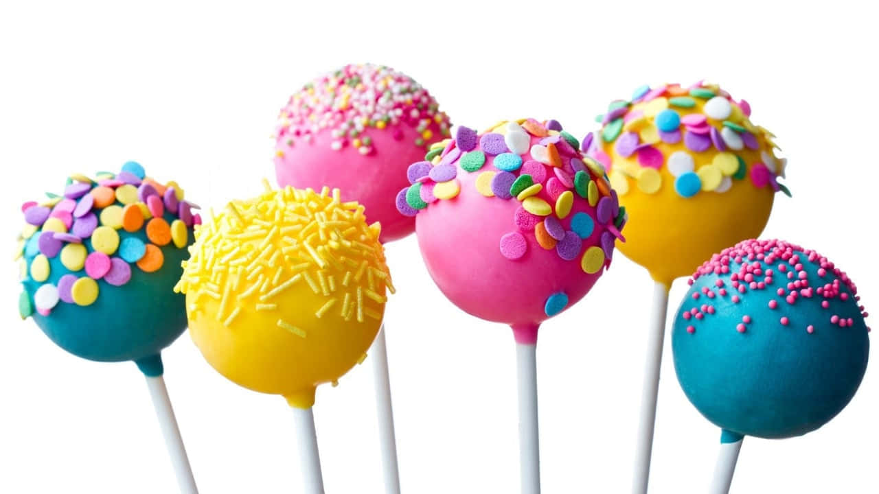 Sprinkles 桌布 壁紙 — 粉紅、黃色和青綠色的鮮豔蛋糕棒，裹上彩色糖粒，立在潔白背景前。