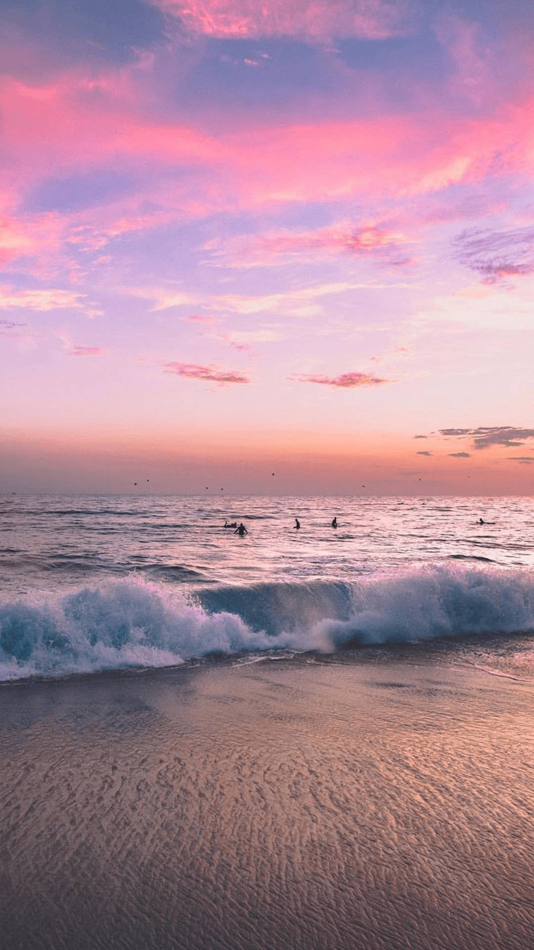 Sunset Aesthetic 桌布 壁紙 — 粉紅和紫色的日落為海灘上空的天空塗上色彩，衝浪者正在乘著溫柔的海浪。