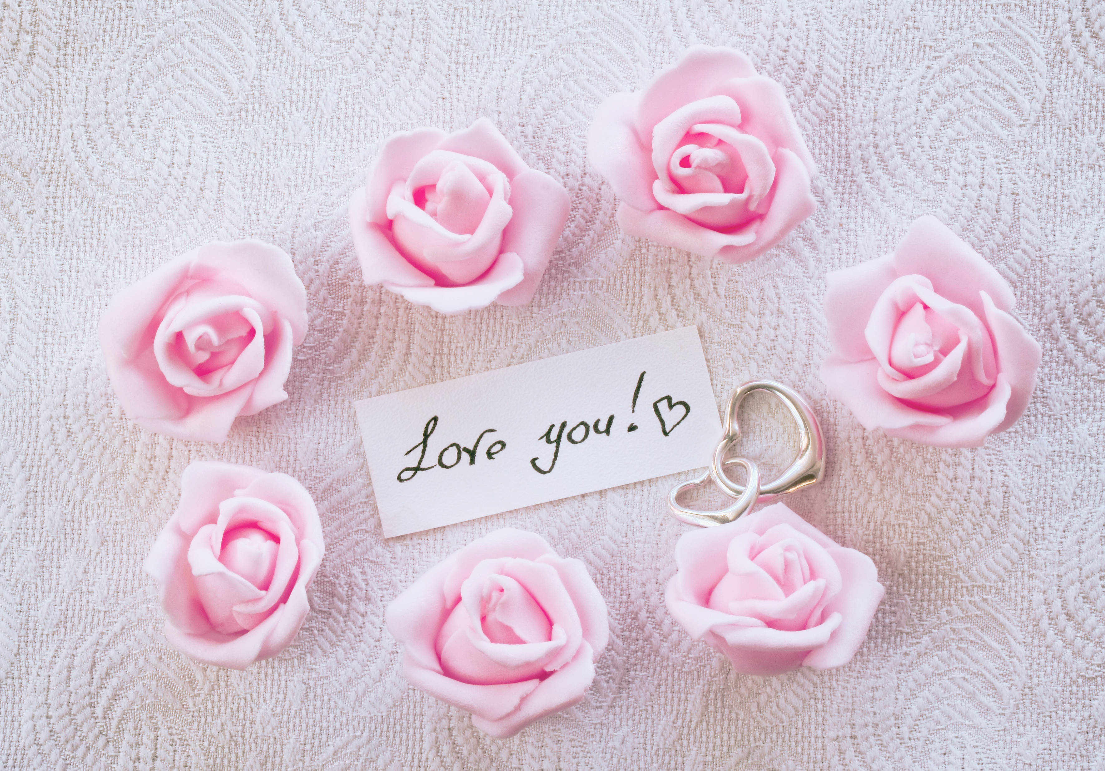 Romantic Rose 桌布 壁紙 — 粉紅玫瑰和手寫字條寫著「Love you!」，配上心形戒指，背景為有紋理的布料。