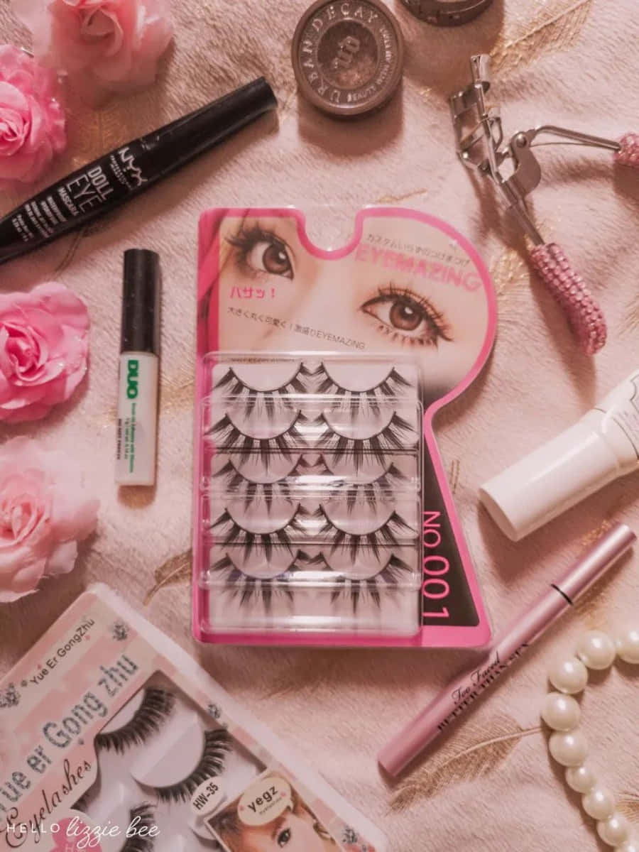 Gyaru 桌布 壁紙 — 粉紅玫瑰與美容產品的平鋪佈局，包括假睫毛、睫毛膏和睫毛夾，排列在柔軟的粉紅色紋理表面上。