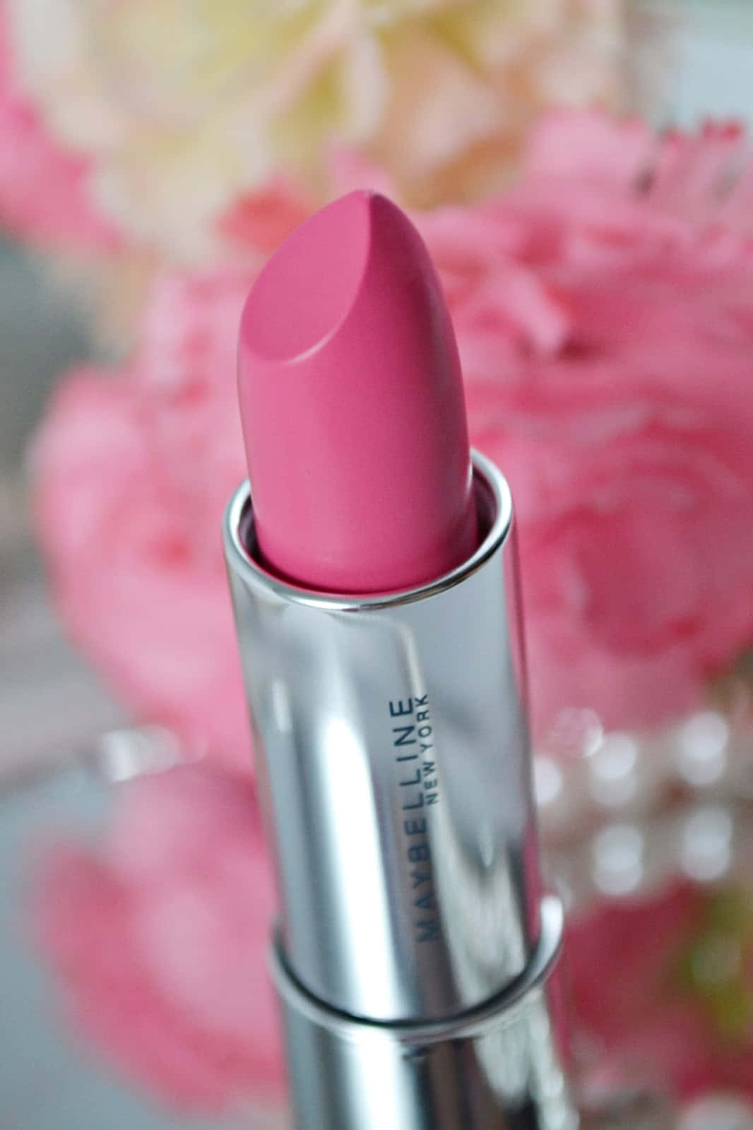 Pink Lipstick 桌布 壁紙 — 粉紅色Maybelline唇膏的特寫，銀色管身，背景是柔焦的粉紅玫瑰。