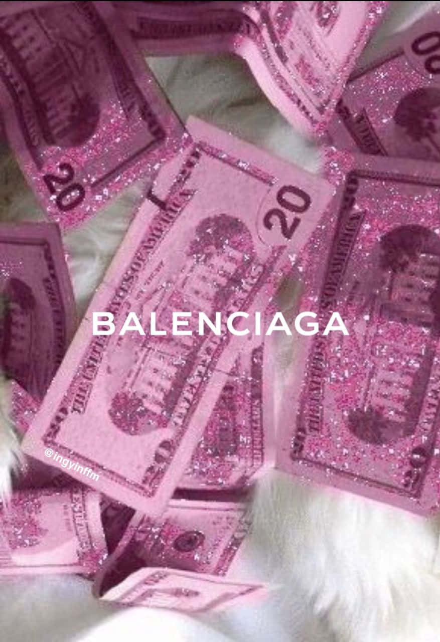 Balenciaga 桌布 壁紙 — 粉紅色亮粉覆蓋的 20 美元鈔票散落在毛絨絨的白色表面上，並帶有 'BALENCIAGA' 文字疊加。