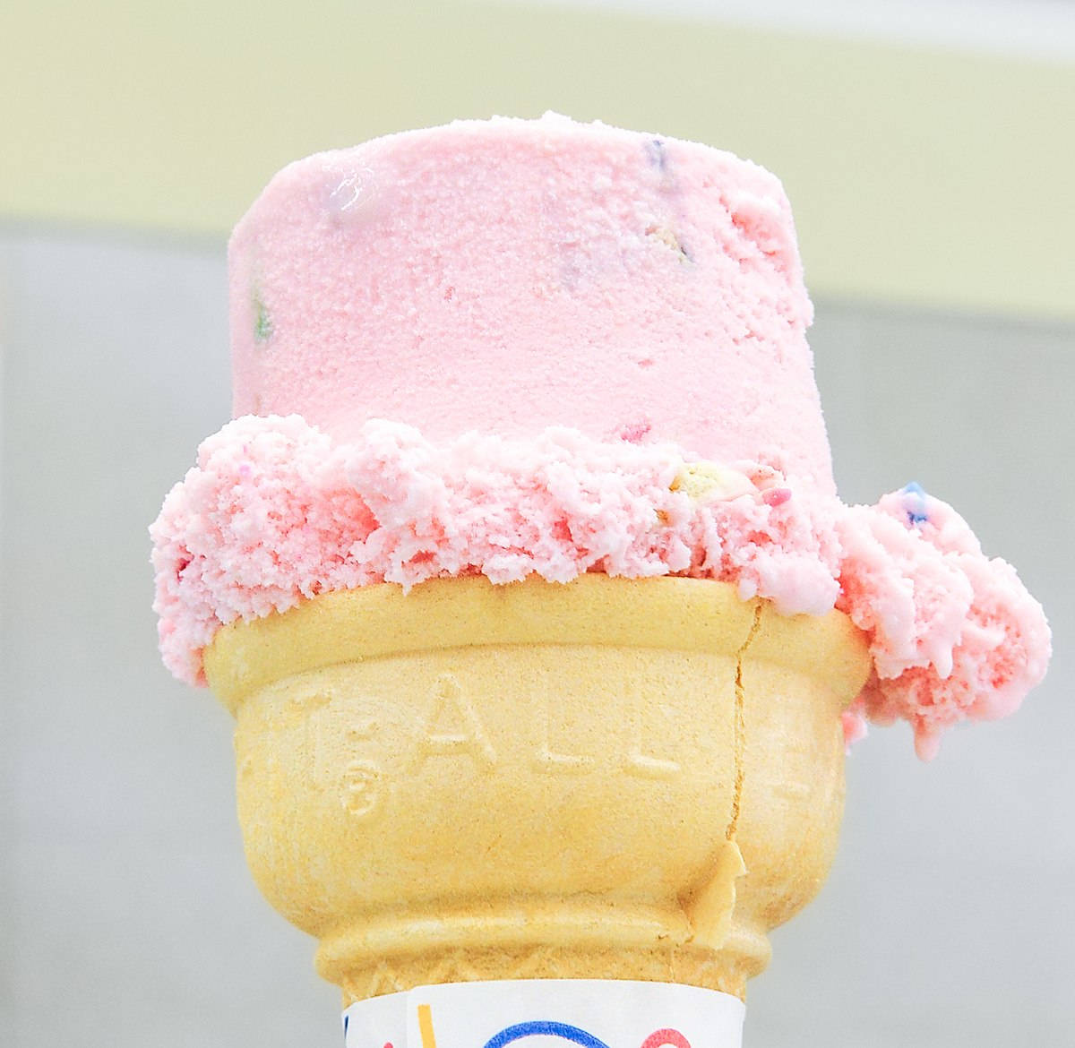 Ice Cream 桌布 壁紙 — 粉紅色冰淇淋甜筒的特寫，上面堆滿了質地柔軟的冰淇淋球和色彩繽紛的糖粒。