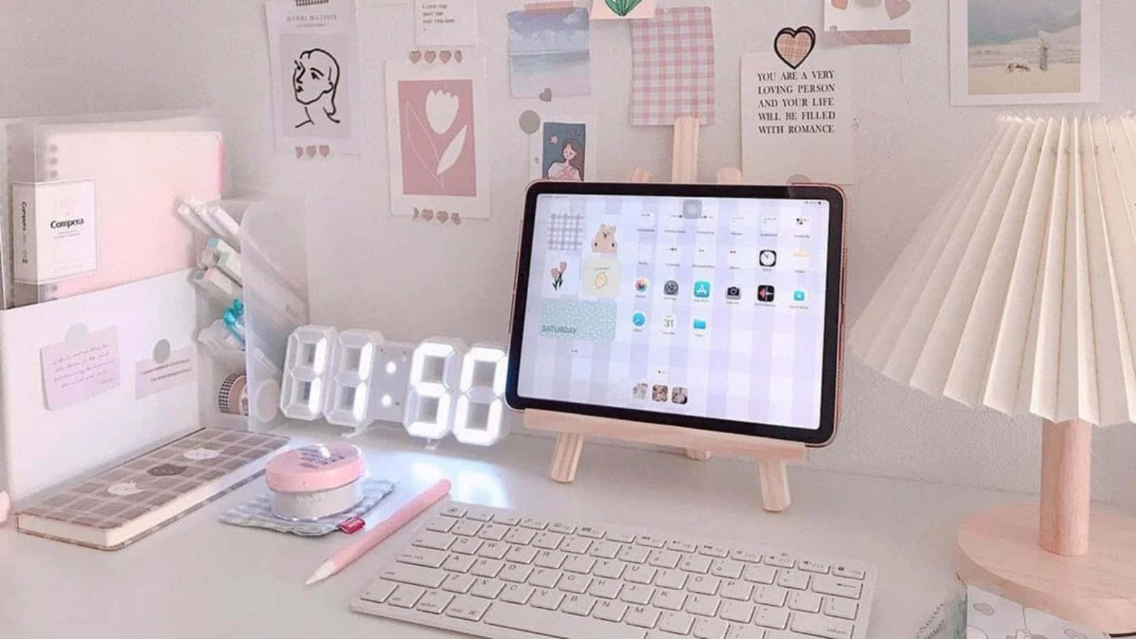 美學 iPad 壁紙 桌布 壁紙 — 粉紅色和白色的書桌設置，配有平板鍵盤燈和裝飾牆藝術，營造舒適的學習氛圍。