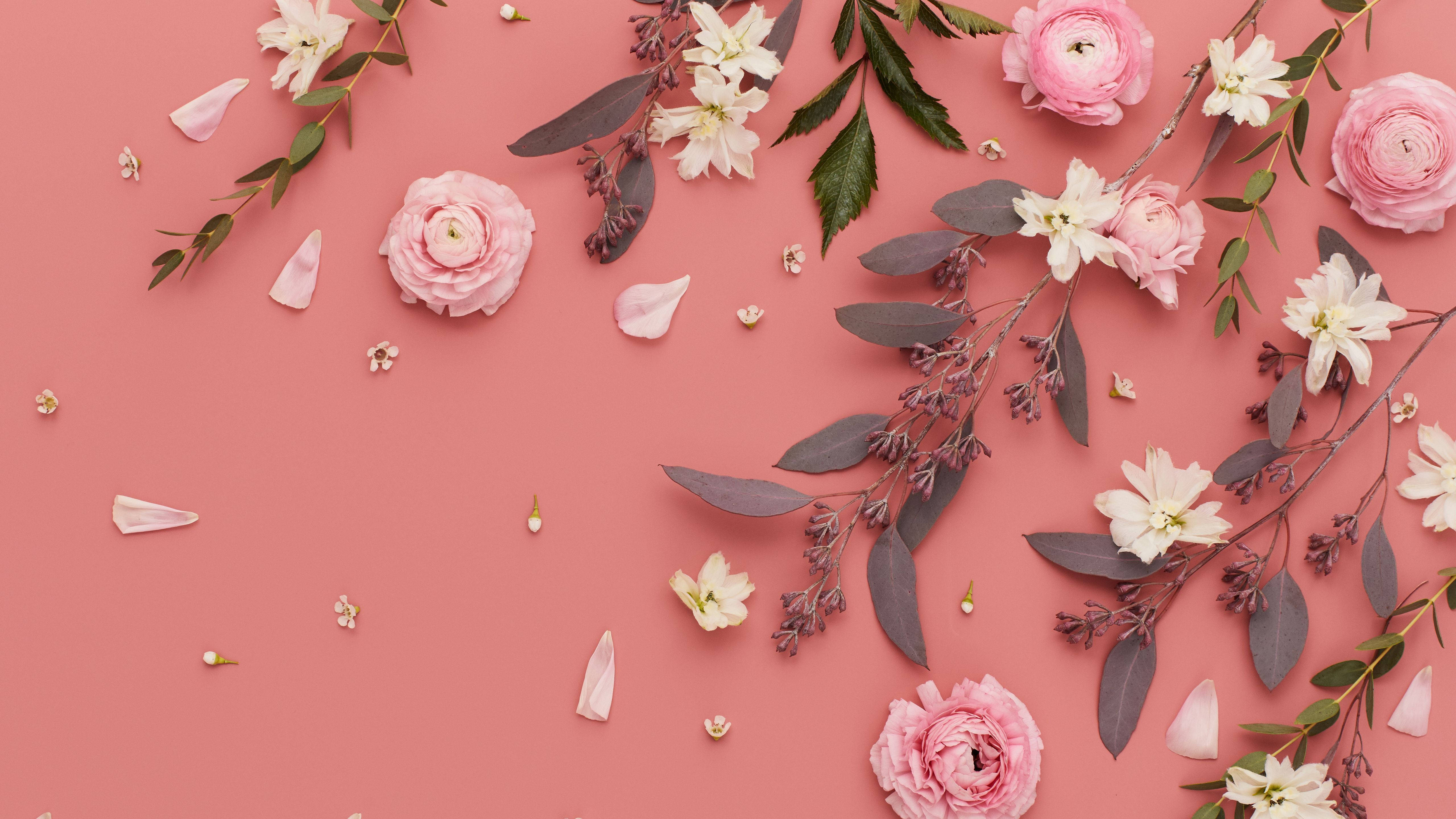 Spring Aesthetic 桌布 壁紙 — 粉紅色和白色的花朵與綠色植物散落在柔軟的珊瑚色背景上，形成平面佈局。