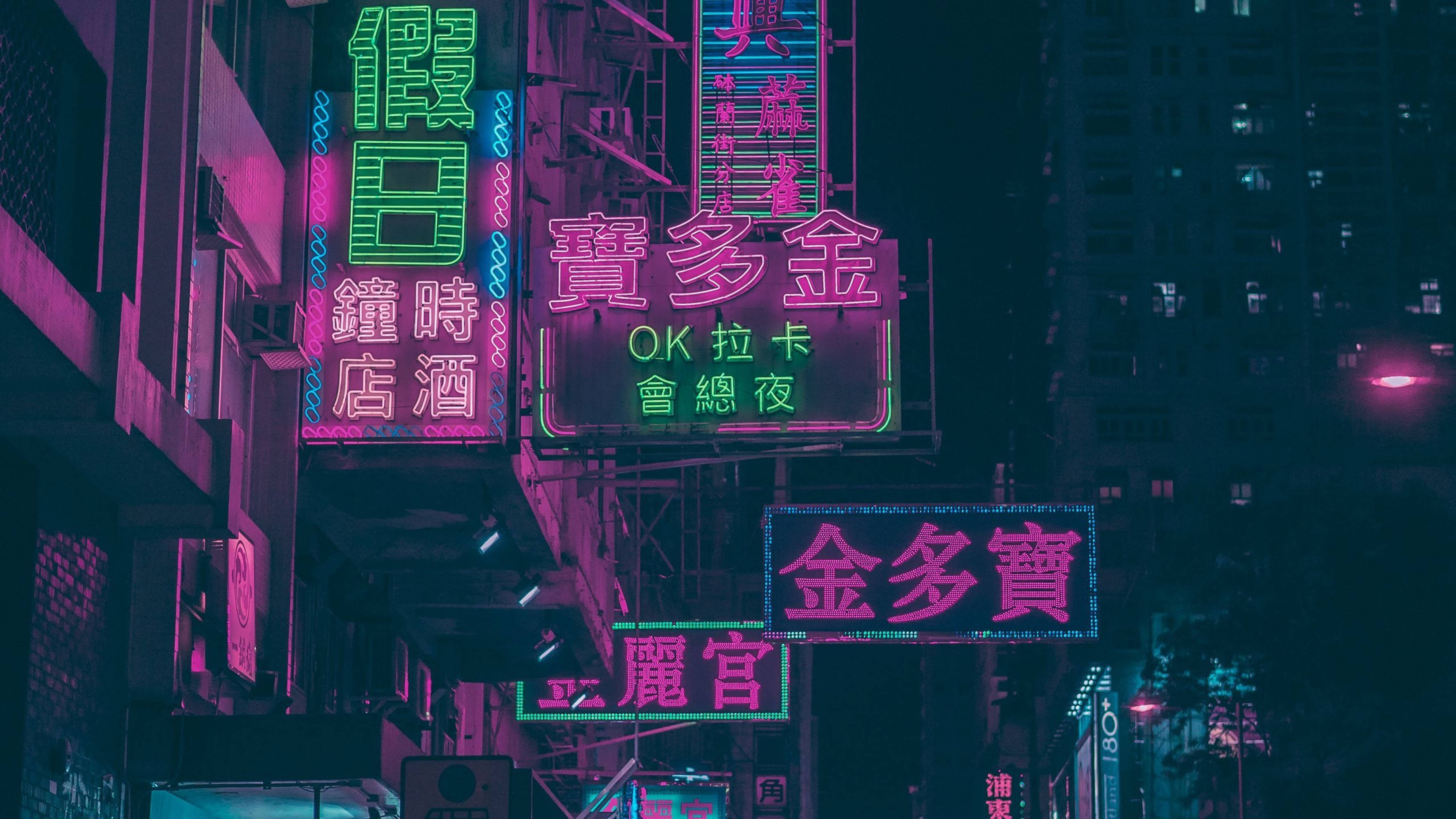 桌布 壁紙 — 粉紅色和綠色的鮮豔霓虹燈在夜晚黑暗的城市天際線上閃耀。