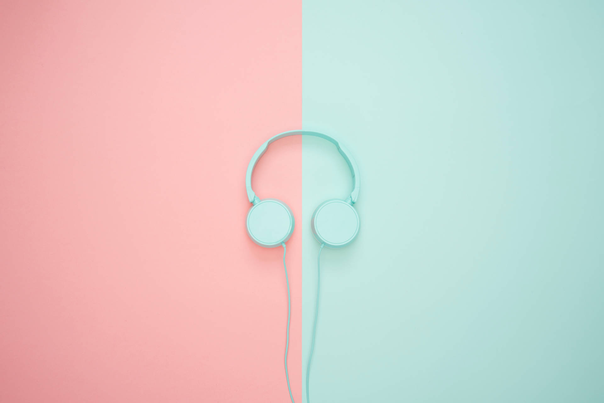 Aesthetic Cute Pastel 桌布 壁紙 — 粉紅色和薄荷綠色分割背景，中央放置簡約淺藍色耳機。