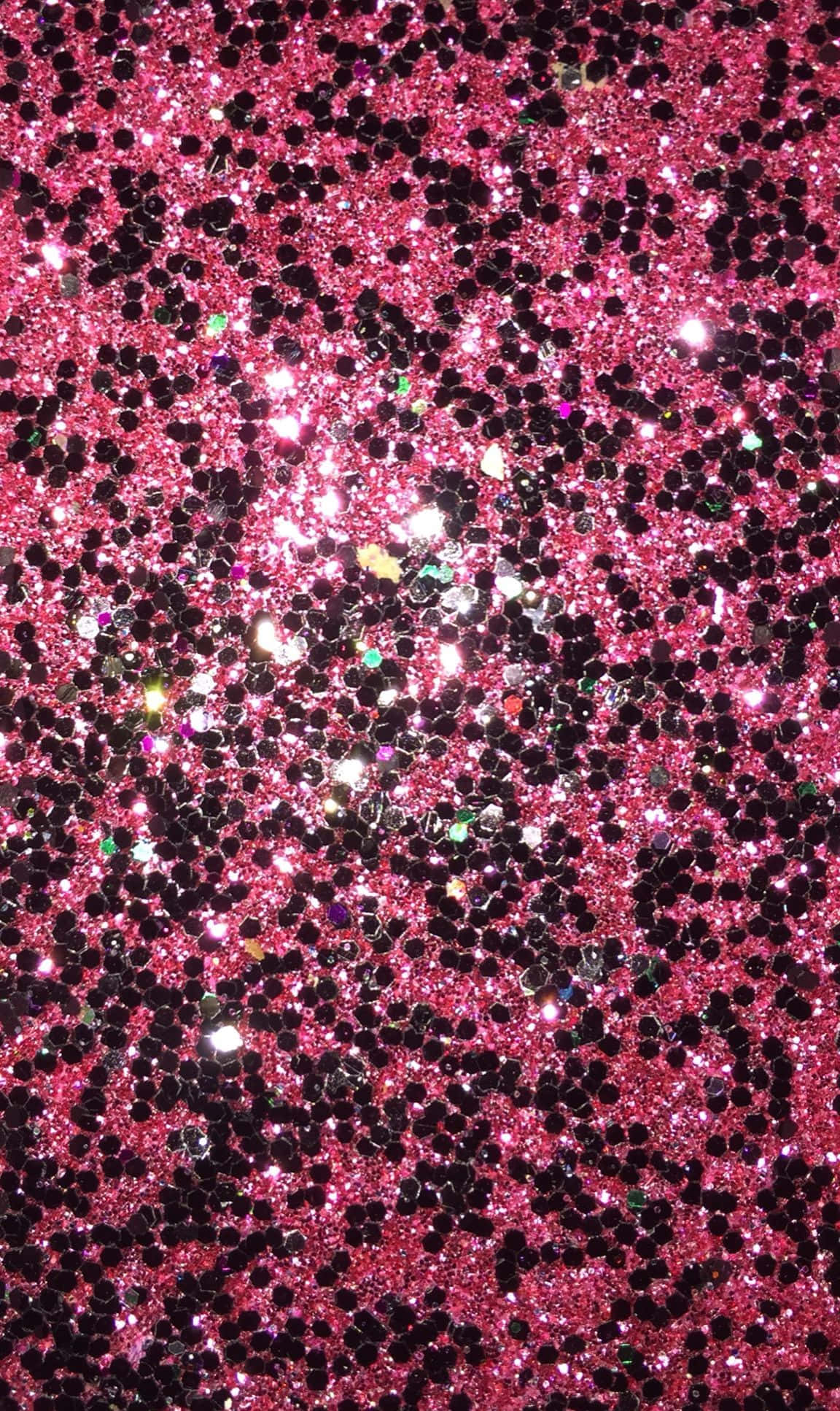 Black And Pink 桌布 壁紙 — 粉紅色和黑色亮粉顆粒在明亮光線下捕捉閃爍混亂圖案的耀眼特寫。
