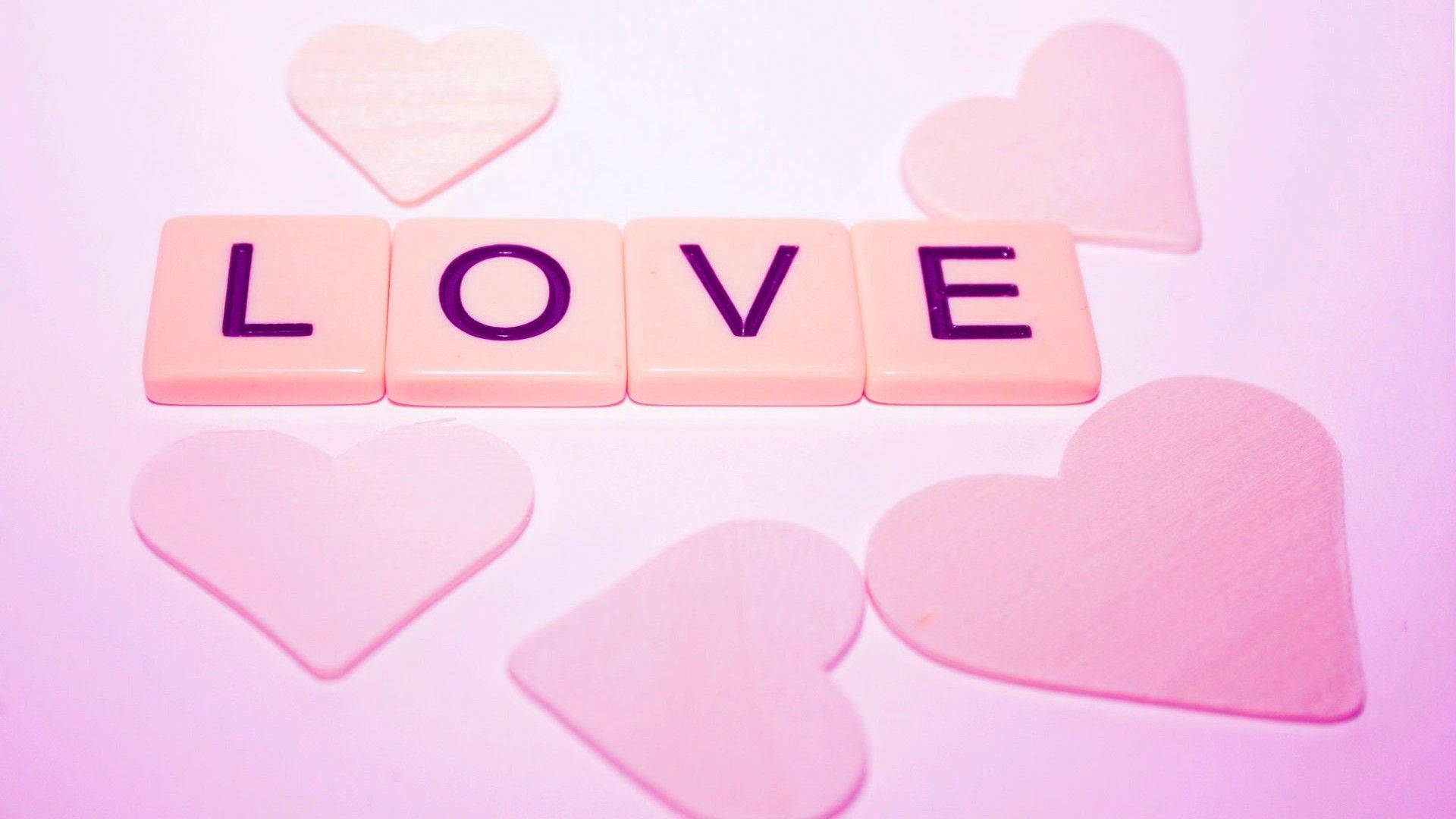 可愛的愛情 桌布 壁紙 — 粉紅色心形瓷磚拼出 LOVE，周圍環繞著柔和粉彩心形，背景為柔和漸變色。