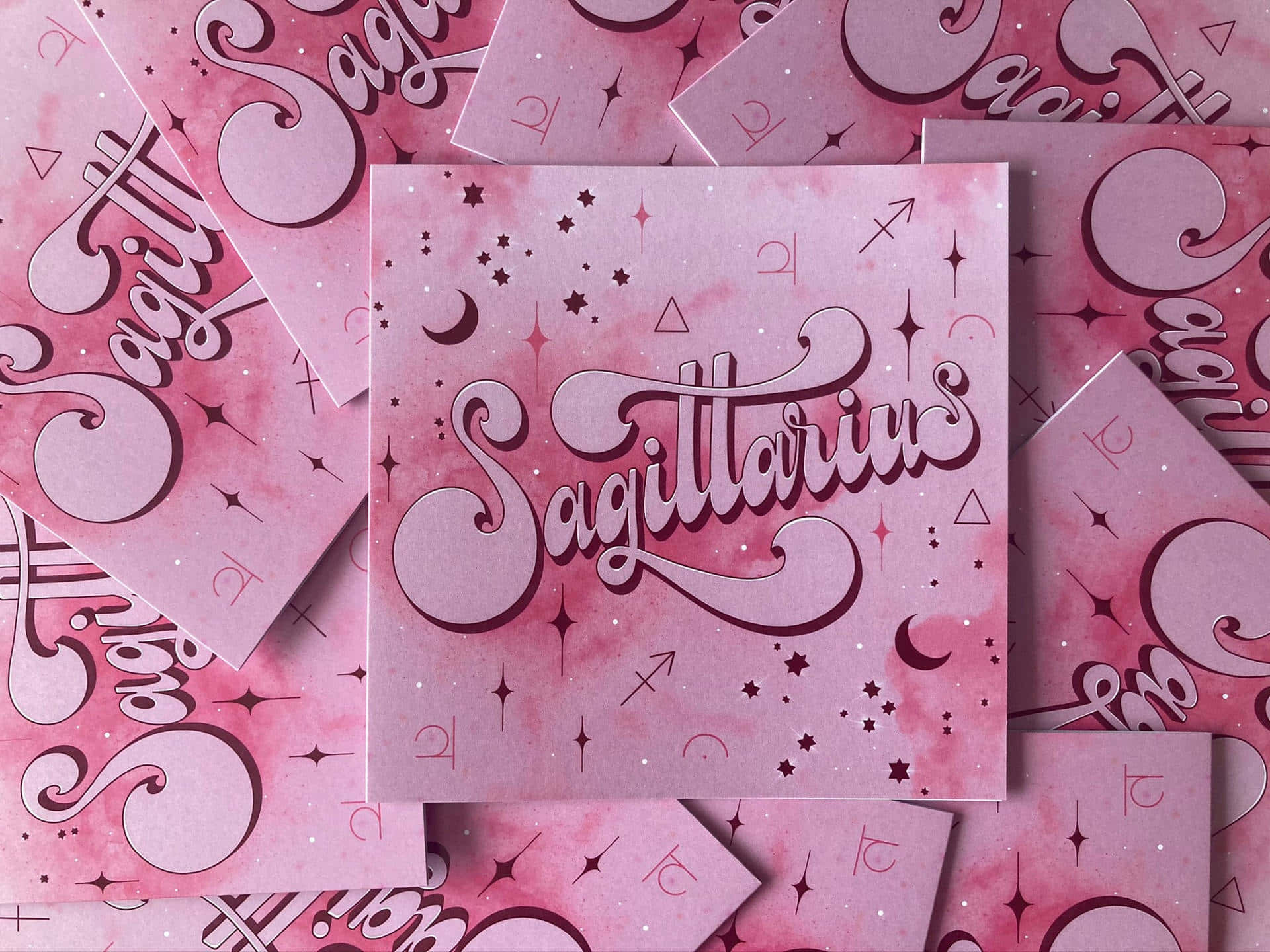 sagittarius 桌布 壁紙 — 粉紅色水彩卡片，帶有優雅的人馬座字體和宇宙符號，散落在分層構圖中。
