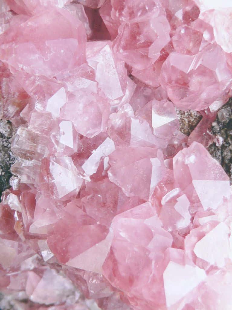 Cute Aesthetic iPad 桌布 壁紙 — 粉紅色玫瑰石英晶體的近距離特寫，在自然光下閃閃發光，具有銳利的幾何刻面。