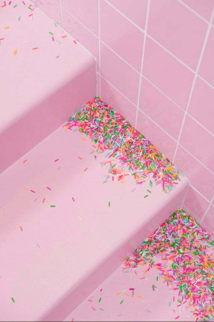 Pastel Pink Aesthetic 桌布 壁紙 — 粉紅色瓷磚樓梯上散落著色彩繽紛的糖果碎屑，營造出甜美夢幻的氛圍。