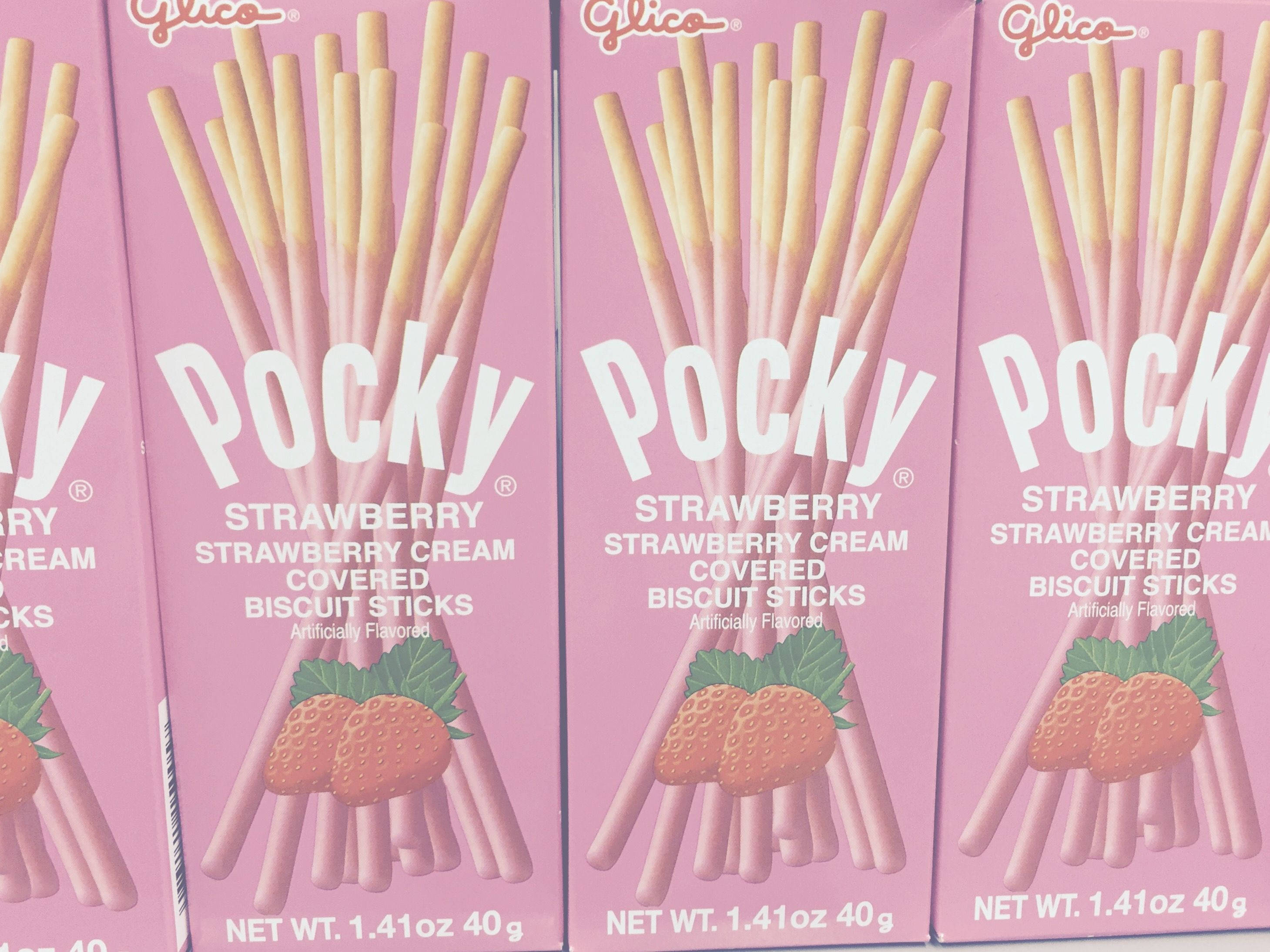 Snacks 桌布 壁紙 — 粉紅色的Glico Pocky草莓奶油餅乾棒盒以重複圖案排列。