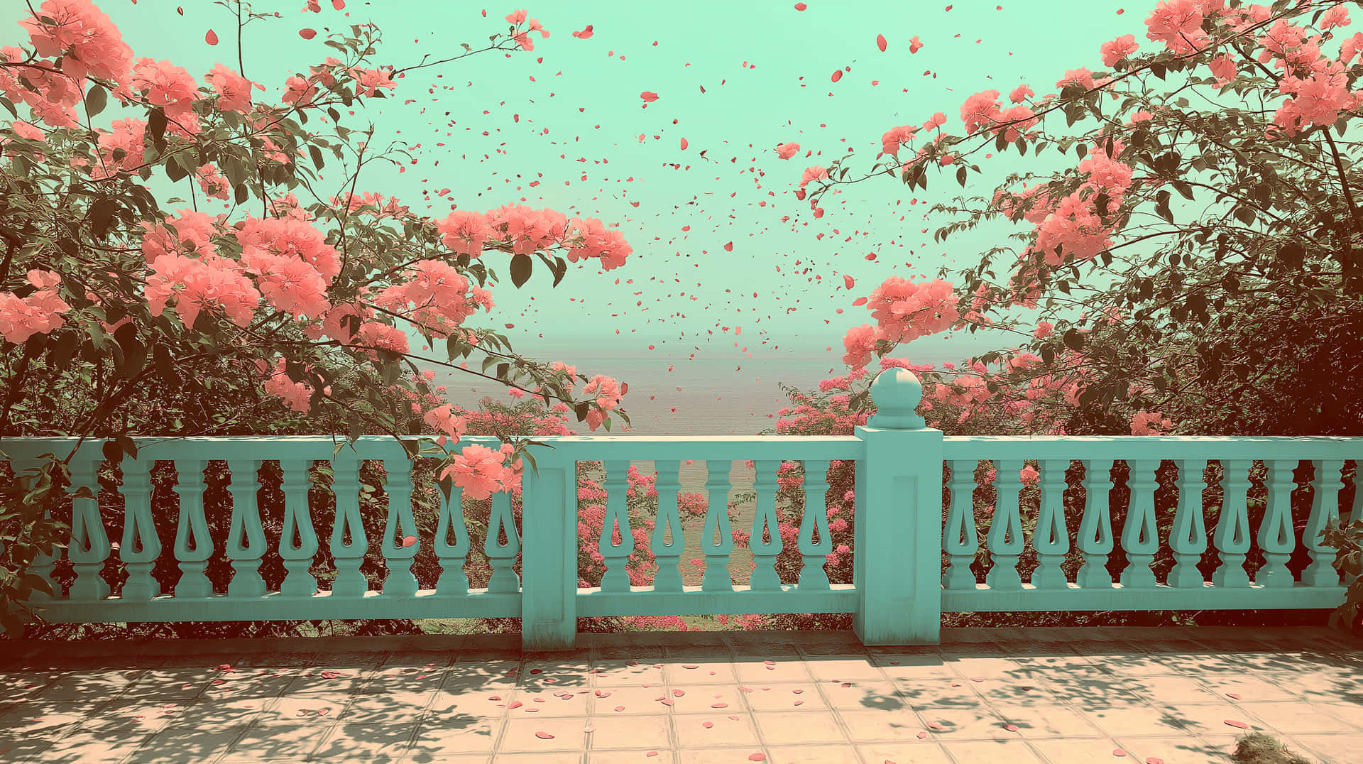 Bougainvillea petals fall over balcony with ocean view 壁紙 — 粉紅色的花朵從盛開的灌木叢中傾瀉而下，越過藍綠色的欄杆，映襯著柔和的青綠色天空。