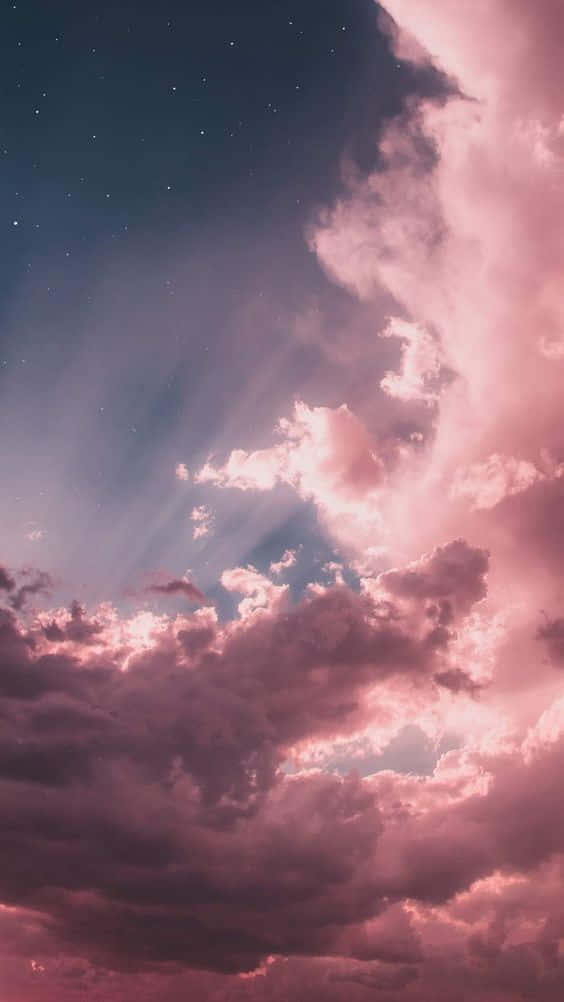 Clouds Aesthetics 桌布 壁紙 — 粉紅色的雲朵在星空下發光，燦爛的陽光穿透戲劇性的雲層。