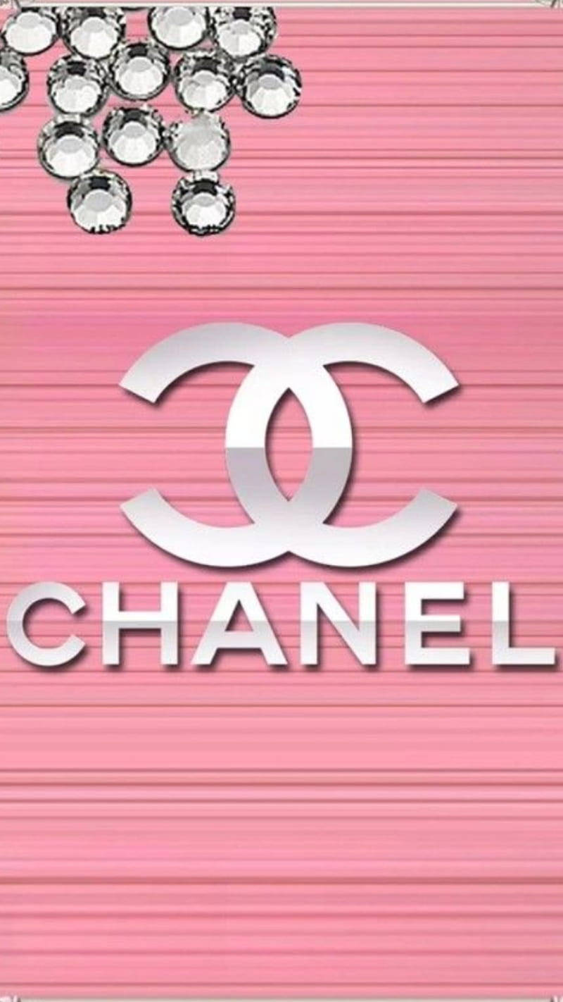 Chanel 桌布 壁紙 — 粉紅色紋理壁紙，左上角有銀色 Chanel 標誌和閃亮水鑽。