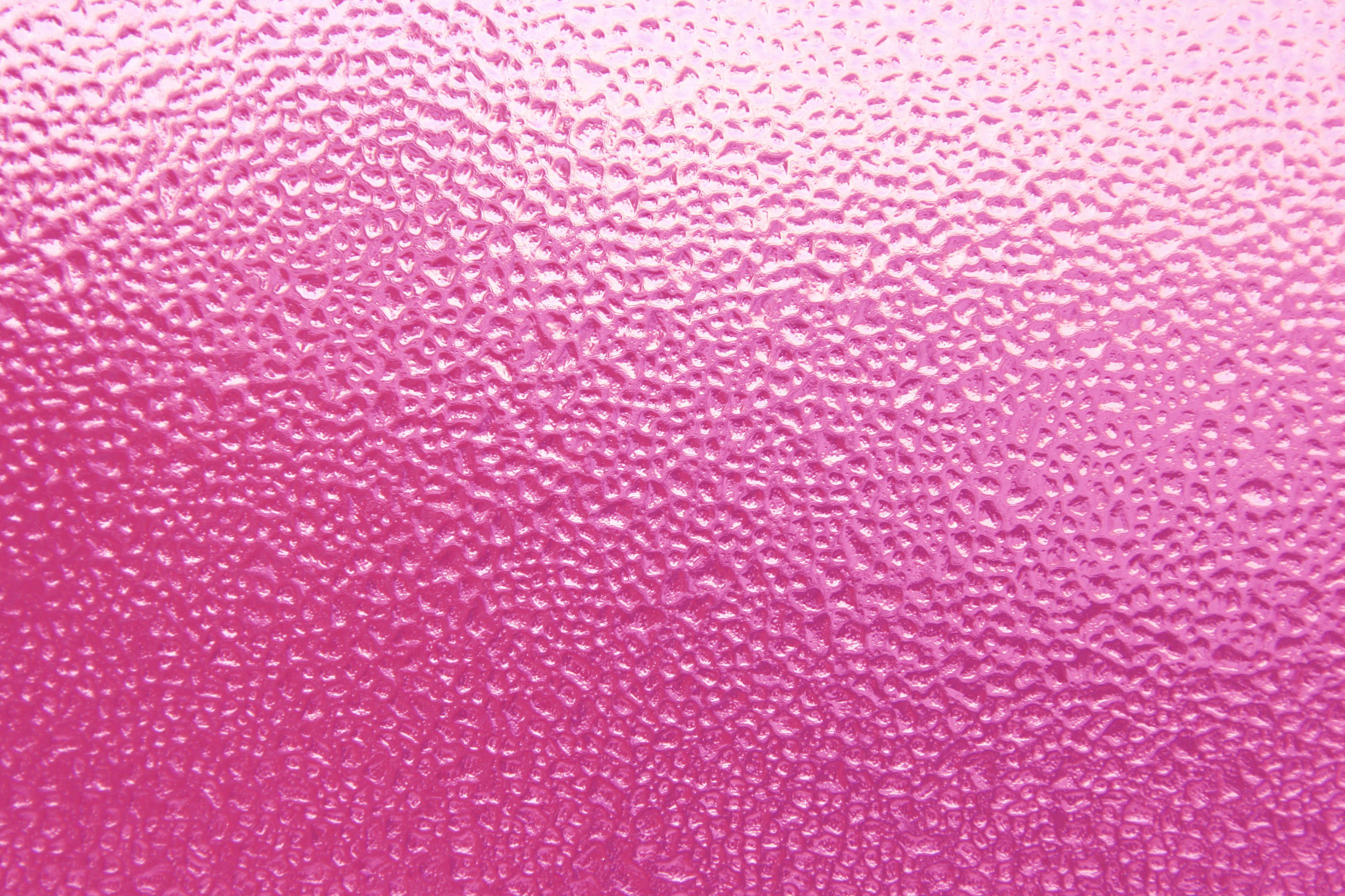 Pink Texture 桌布 壁紙 — 粉紅色紋理表面的特寫，水滴在柔和光線下閃閃發光。