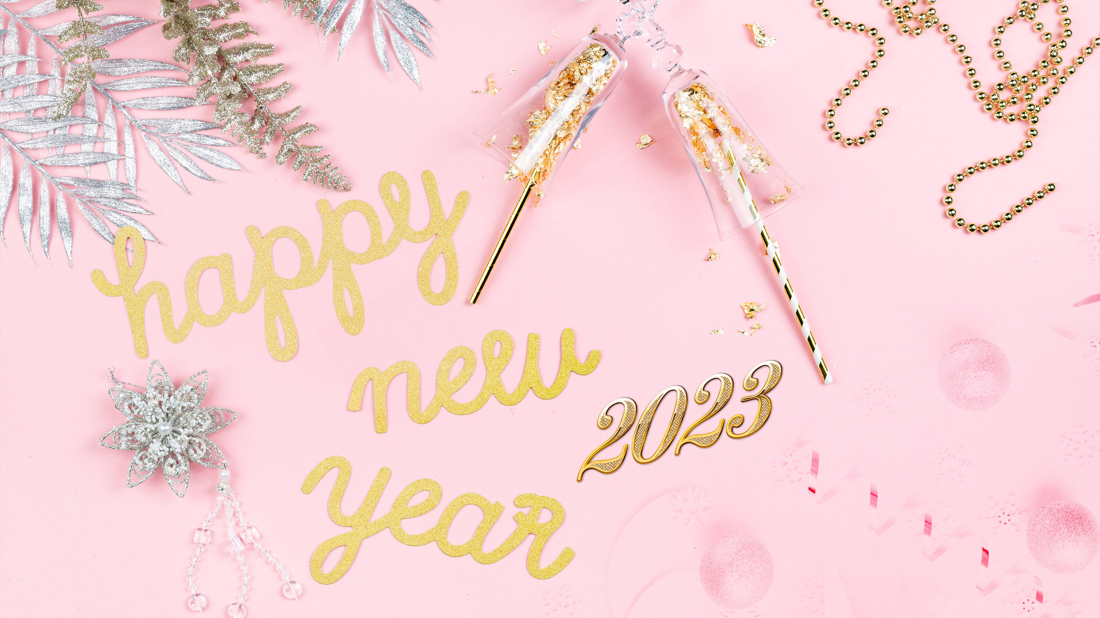 Greetings 桌布 壁紙 — 粉紅色背景飾有金色閃粉文字，寫著「新年快樂2023」，周圍環繞著銀色樹葉和節日裝飾。