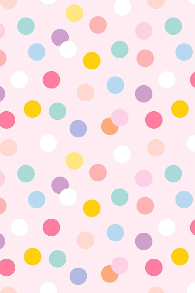 Polka Dot 桌布 壁紙 — 粉紅色背景點綴著色彩繽紛的散落圓點，呈現柔和彩虹色調。