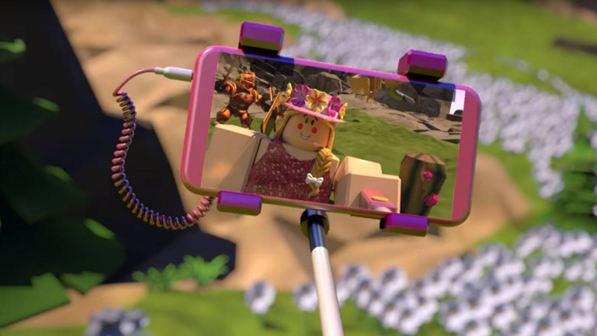 Roblox Girl 桌布 壁紙 — 粉紅色自拍棒拿著一支手機，顯示一個戴著花冠的 Roblox 角色在長滿白花的草地上自拍。