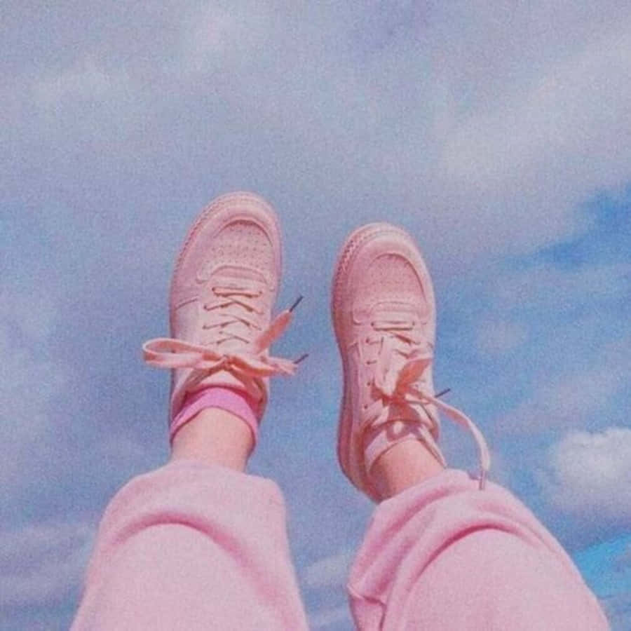 Pink Shoes 桌布 壁紙 — 粉紅色運動鞋和運動褲在柔和的藍天白雲中漂浮。