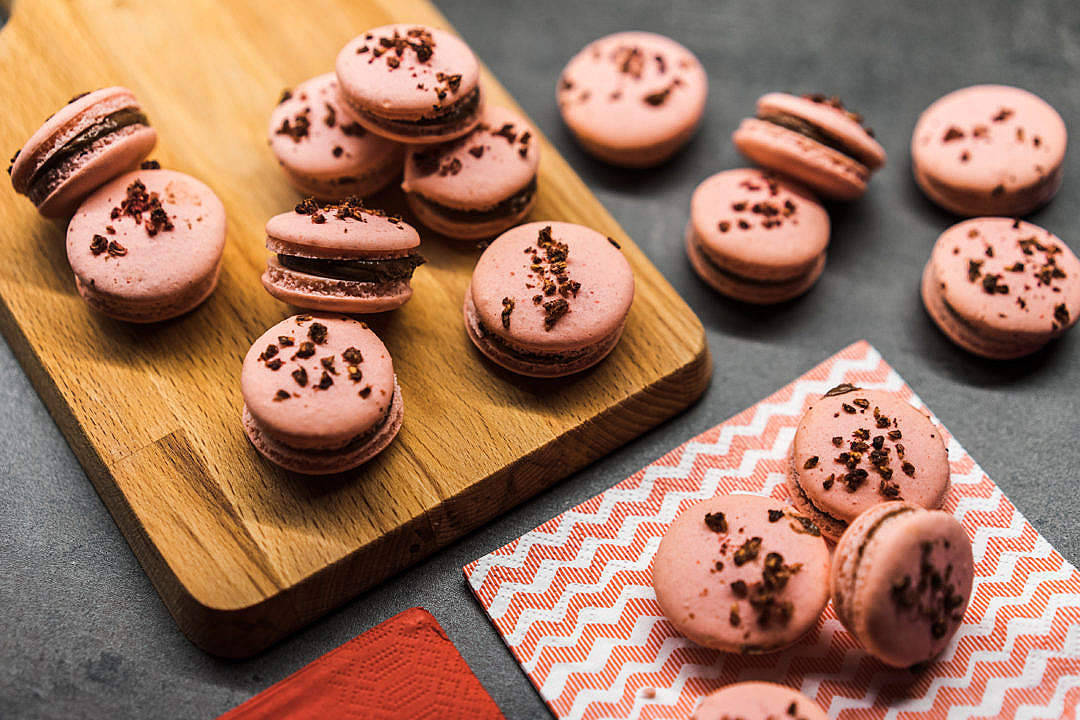 Pastel Pink Aesthetic 桌布 壁紙 — 粉紅色馬卡龍搭配巧克力甘納許和巧克力碎屑，放在木板上和圖案餐巾上。