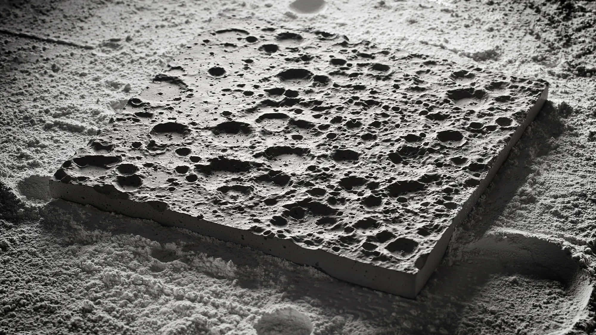 太空 桌布 壁紙 — 粉雪中嵌入的紋理混凝土板的單色特寫，帶有深邃陰影和清晰高光。